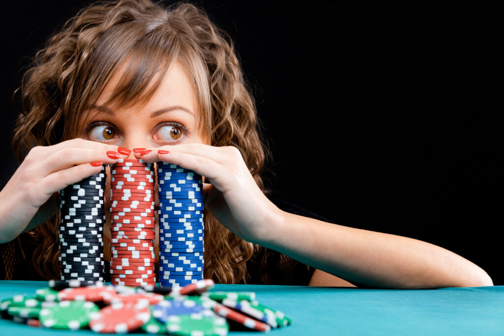 girl peeking over poker chips